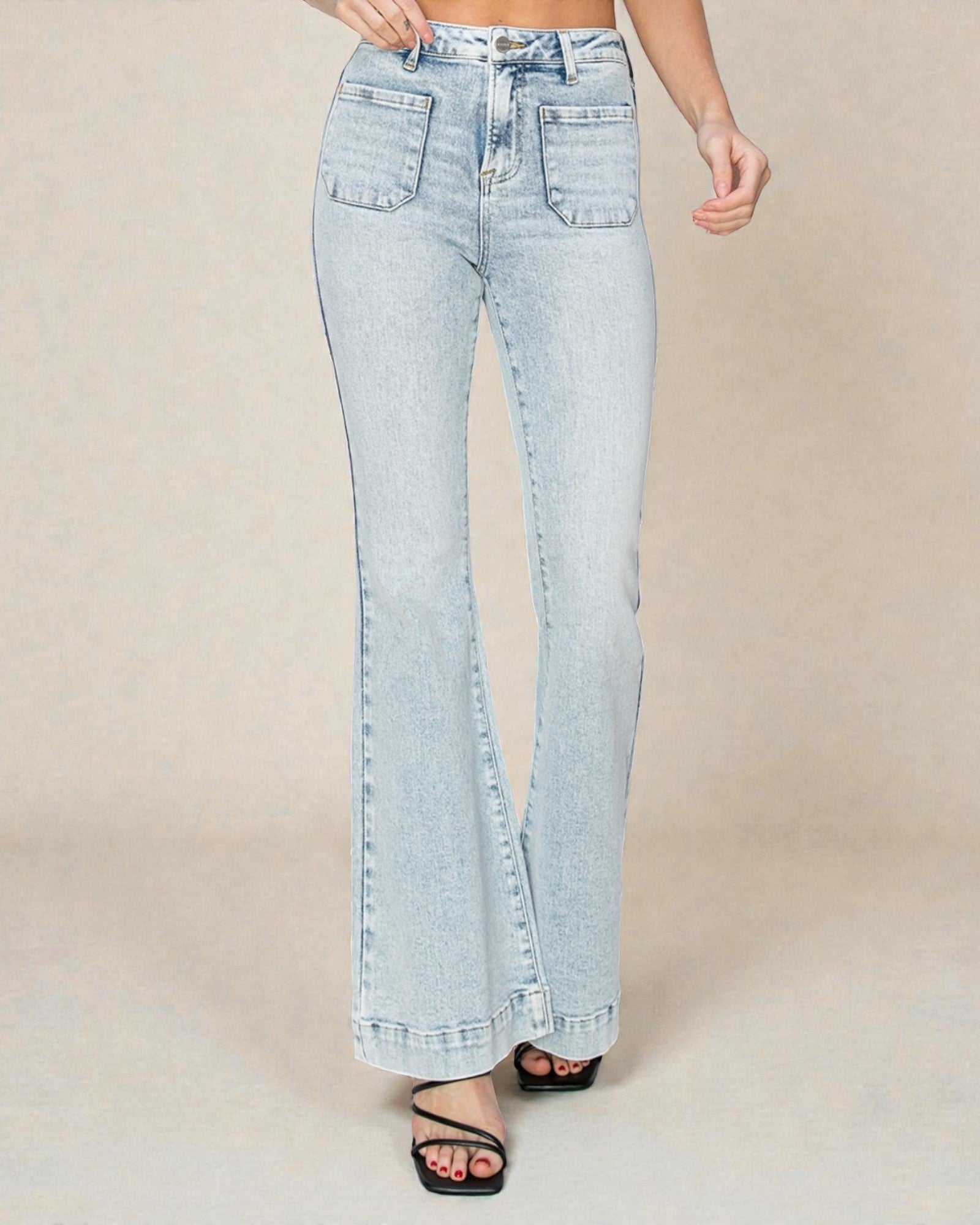 Light blue jeans worn by a person on a beige background