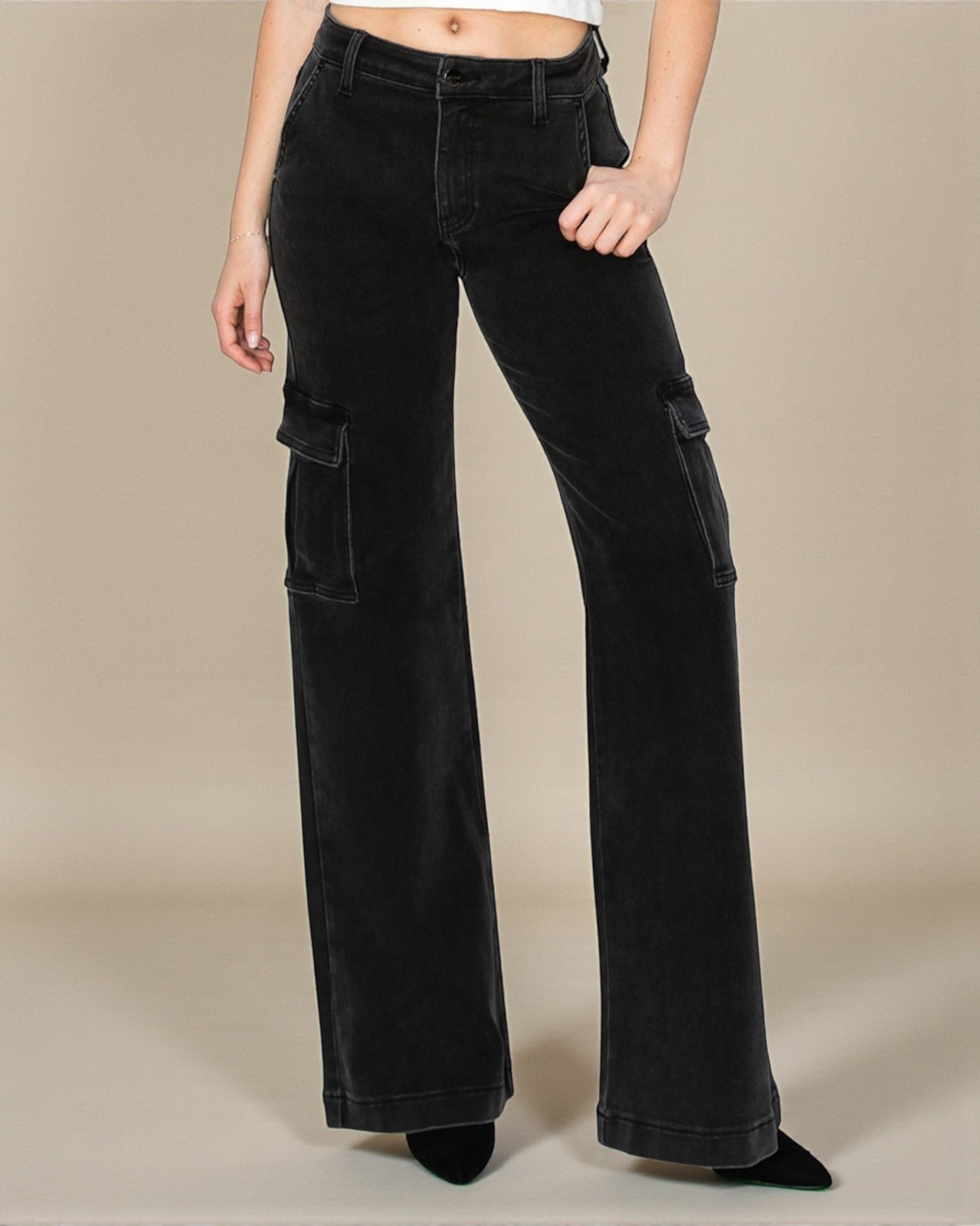 Black cargo pants worn by a person on a beige background