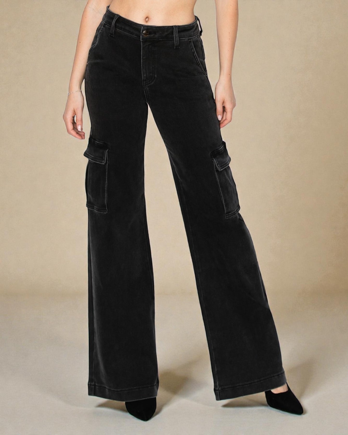 Black wide-leg pants with cargo pockets worn by a person on a beige background