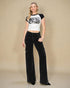 Woman wearing a graphic t-shirt and black cargo pants on a beige background