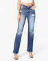 A model wearing a pair of medium-wash blue distressed jeans with ripped knees and frayed hems, paired with clear high-heeled sandals against a plain white background.