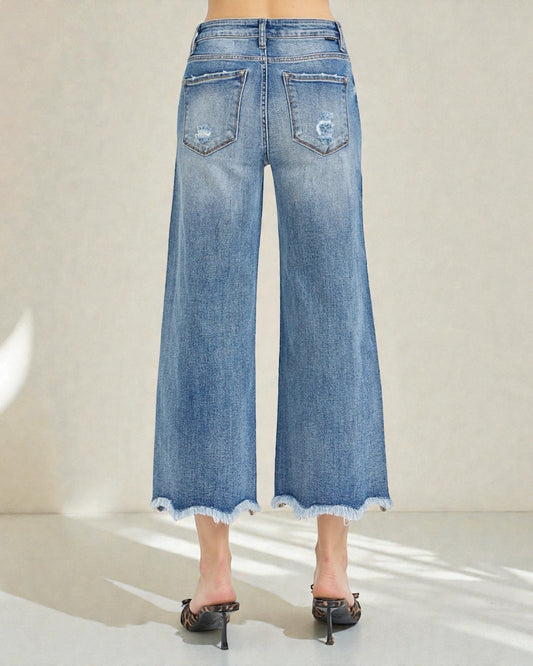 Blue denim wide-leg jeans worn by a person on a white background