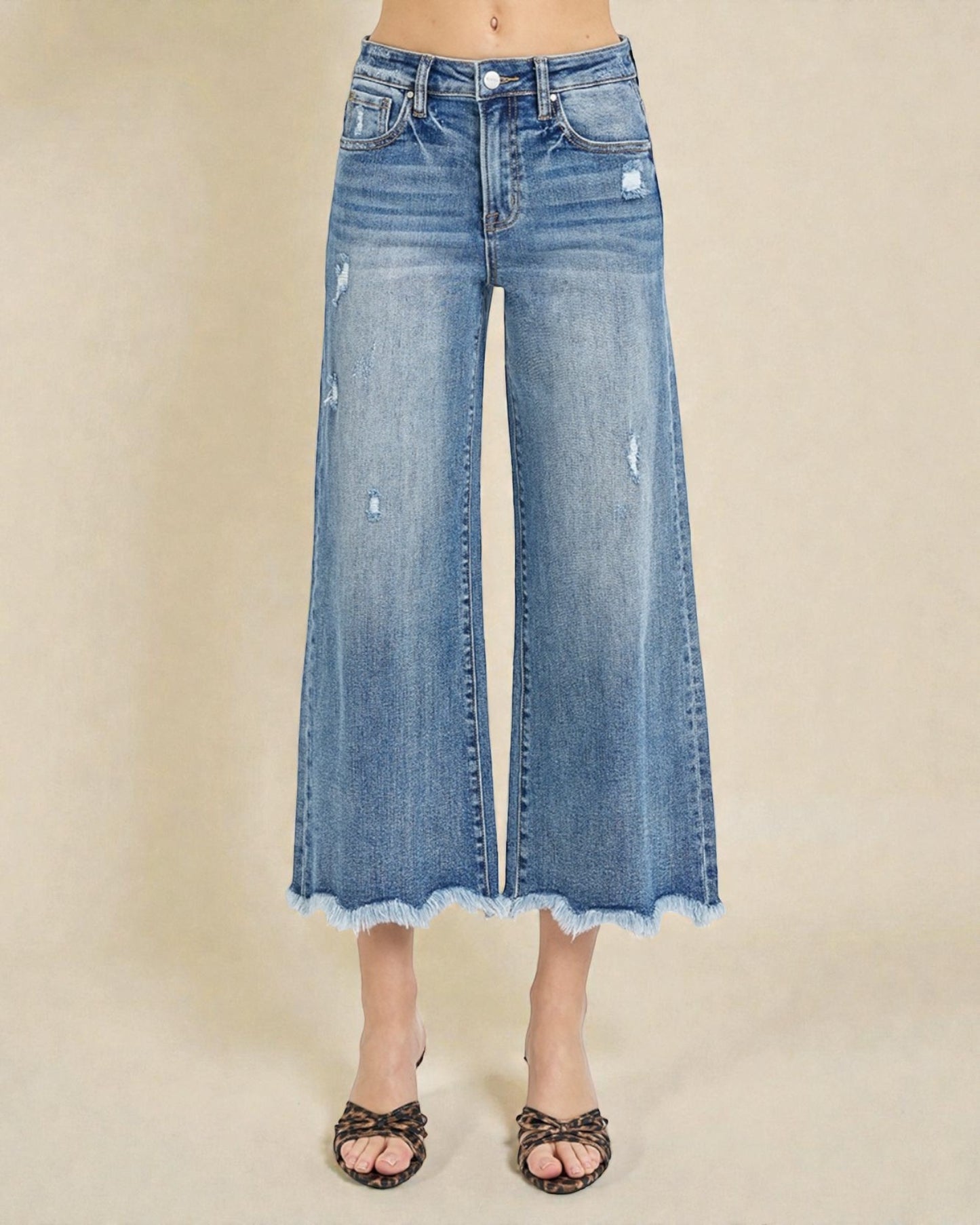 Wide-leg blue jeans on a beige background