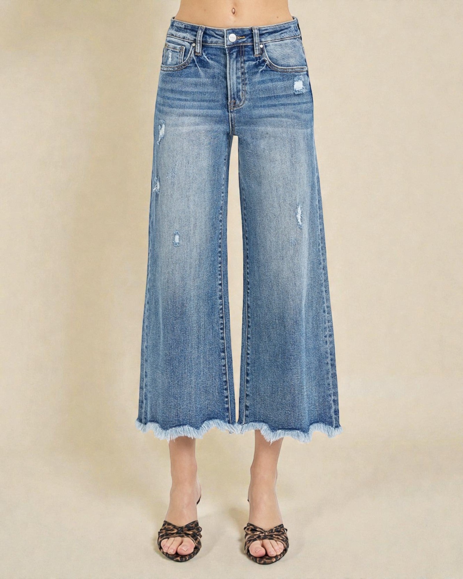 Wide-leg blue jeans on a beige background