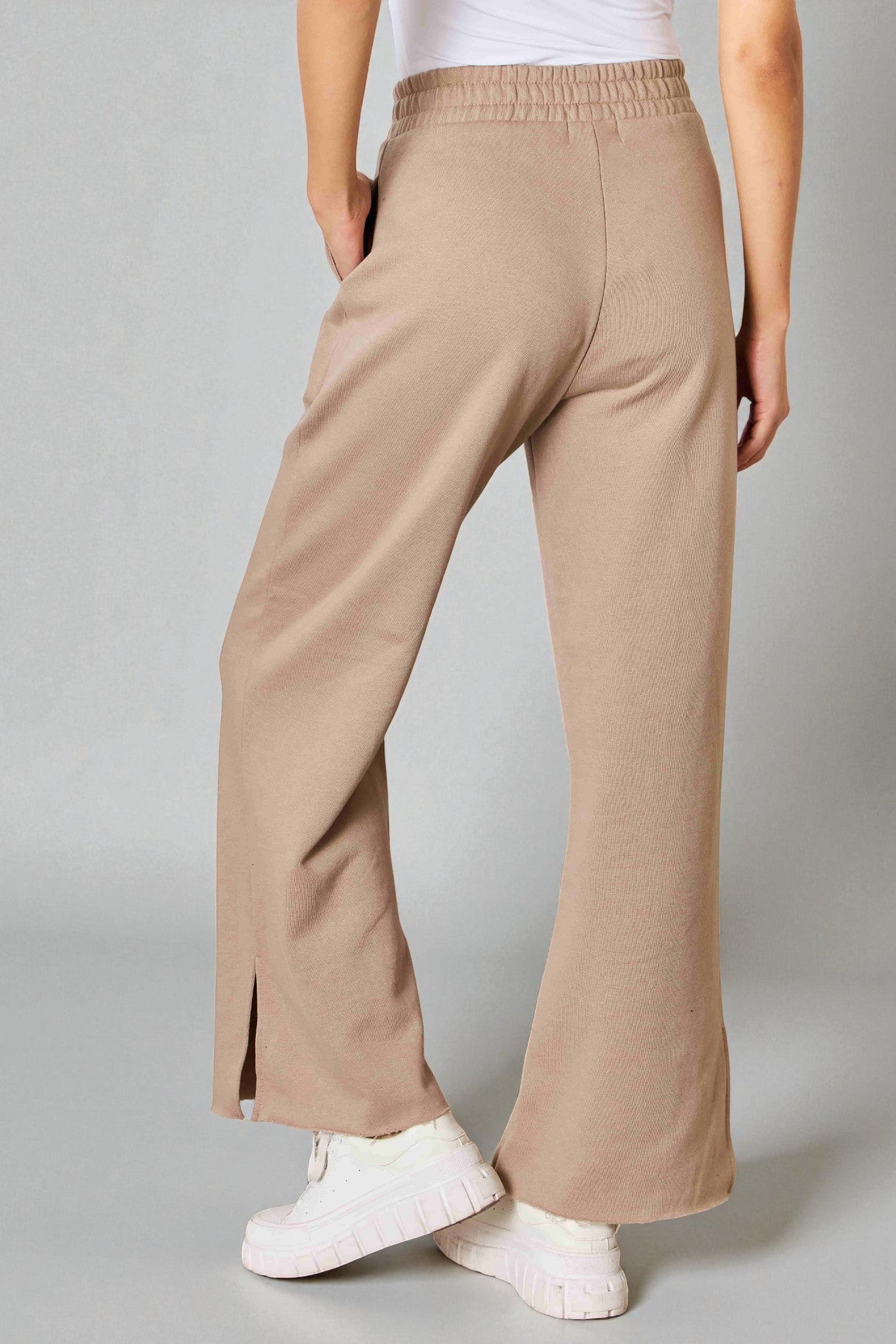 Beige pants worn by a person on a gray background