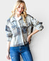 Woman wearing a plaid jacket and blue jeans against a white background