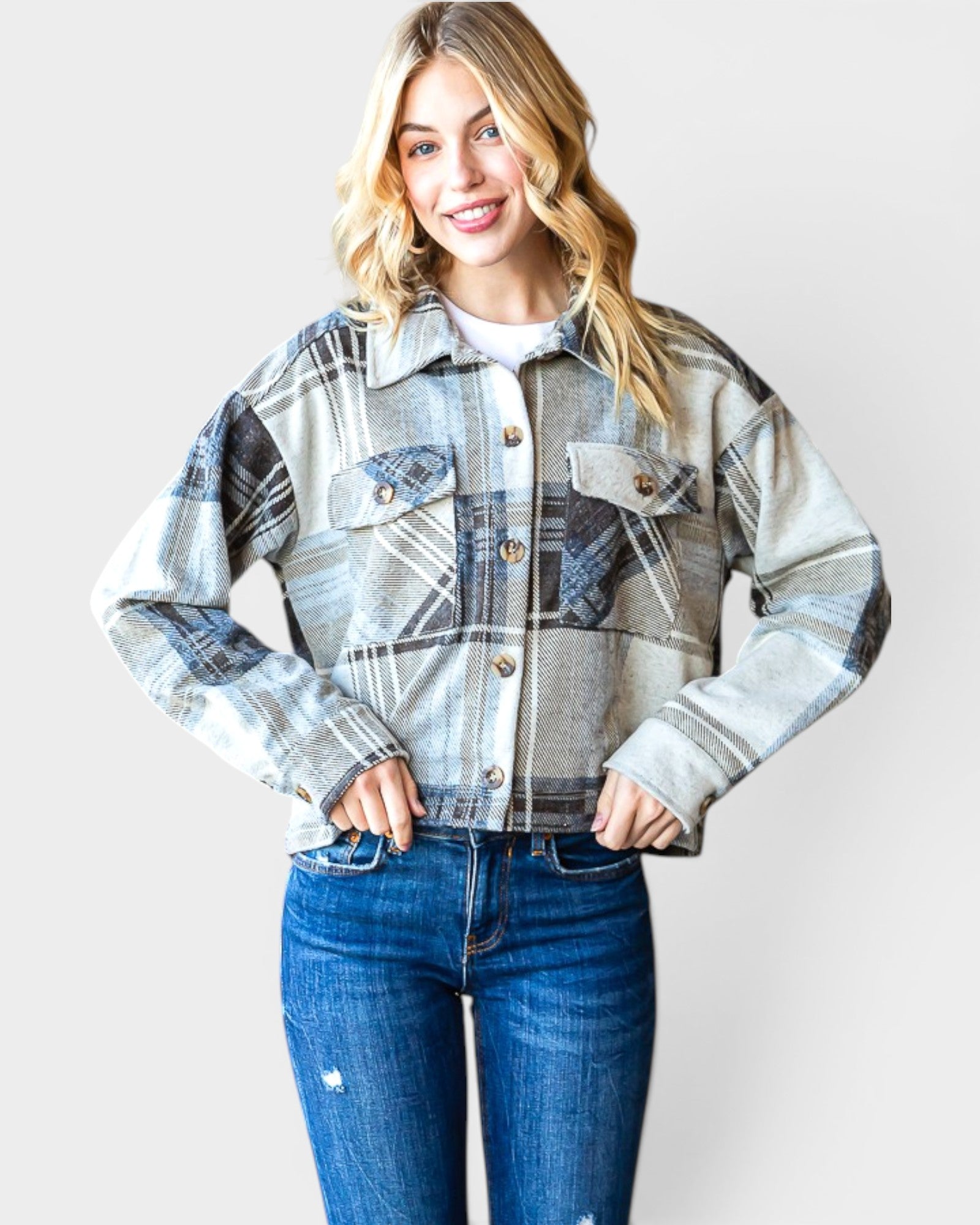Woman wearing a plaid jacket and jeans on a white background
