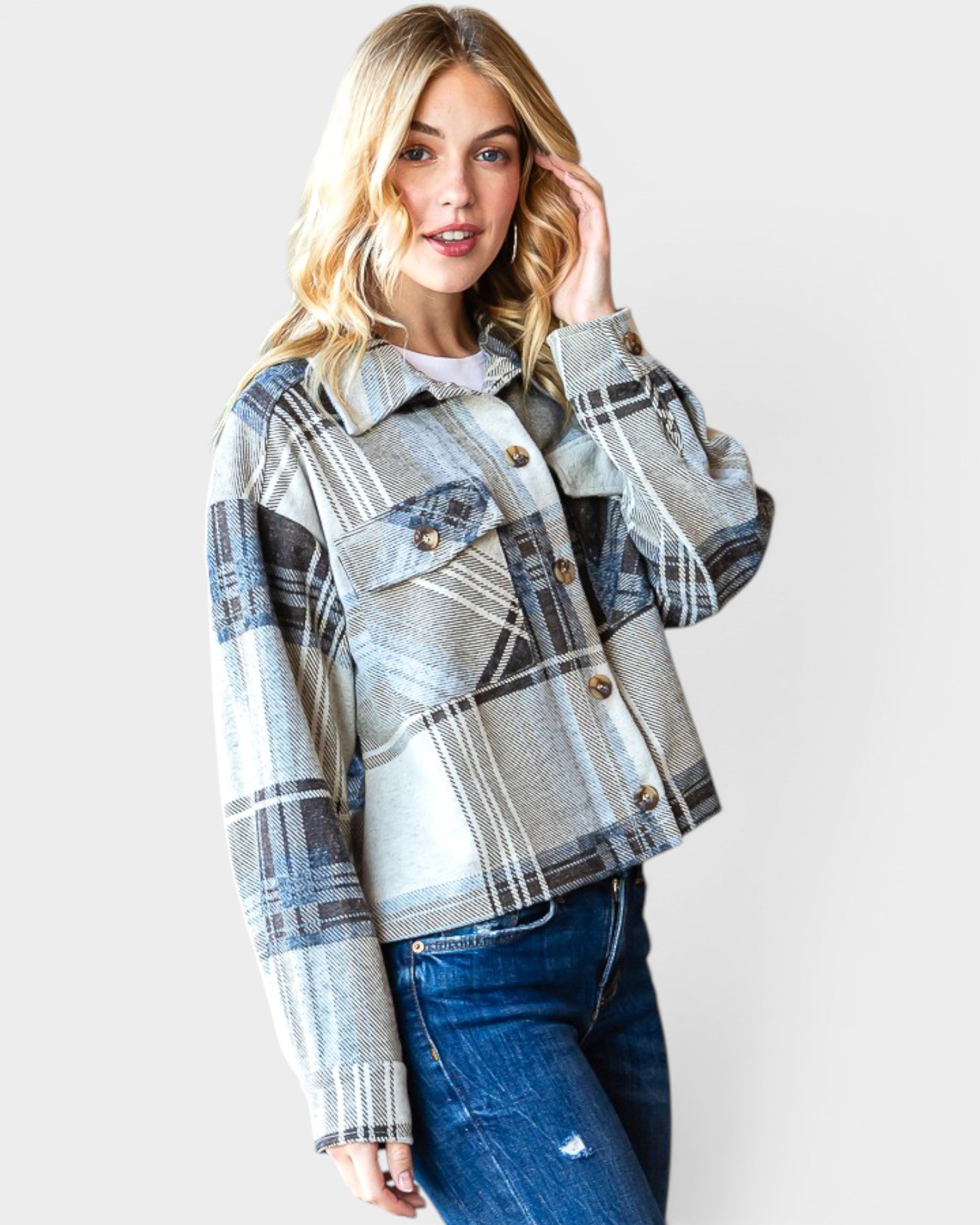 Woman wearing a plaid jacket and jeans on a white background