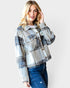 Woman wearing a plaid jacket and jeans on a white background