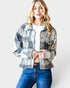 Woman wearing a plaid jacket and blue jeans on a white background