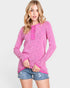 Woman wearing a pink long-sleeve top and denim shorts on a white background