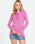 Woman wearing a pink long-sleeve top with a white background