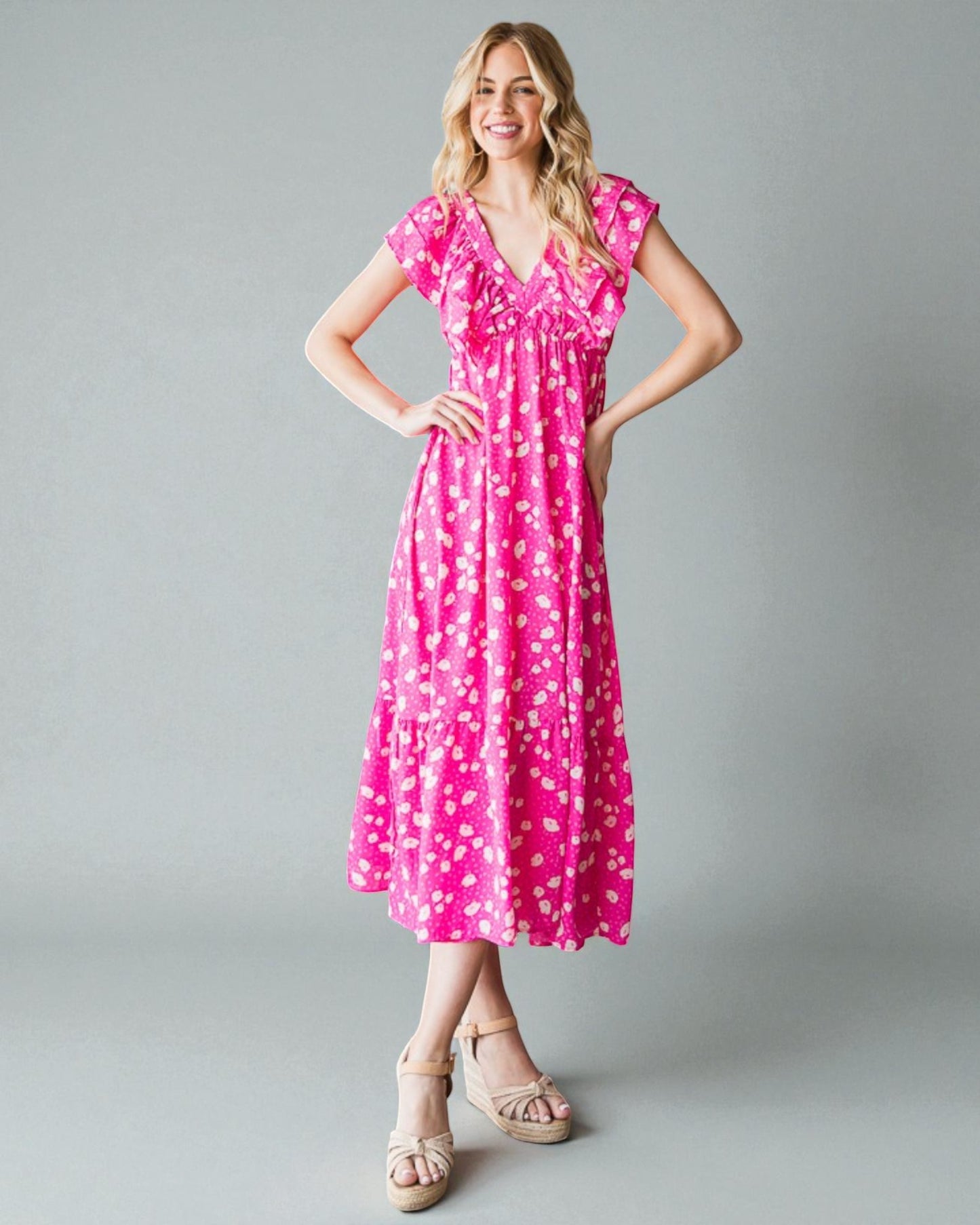 Woman wearing a pink floral dress on a gray background