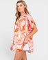 Woman wearing a colorful floral top on a white background