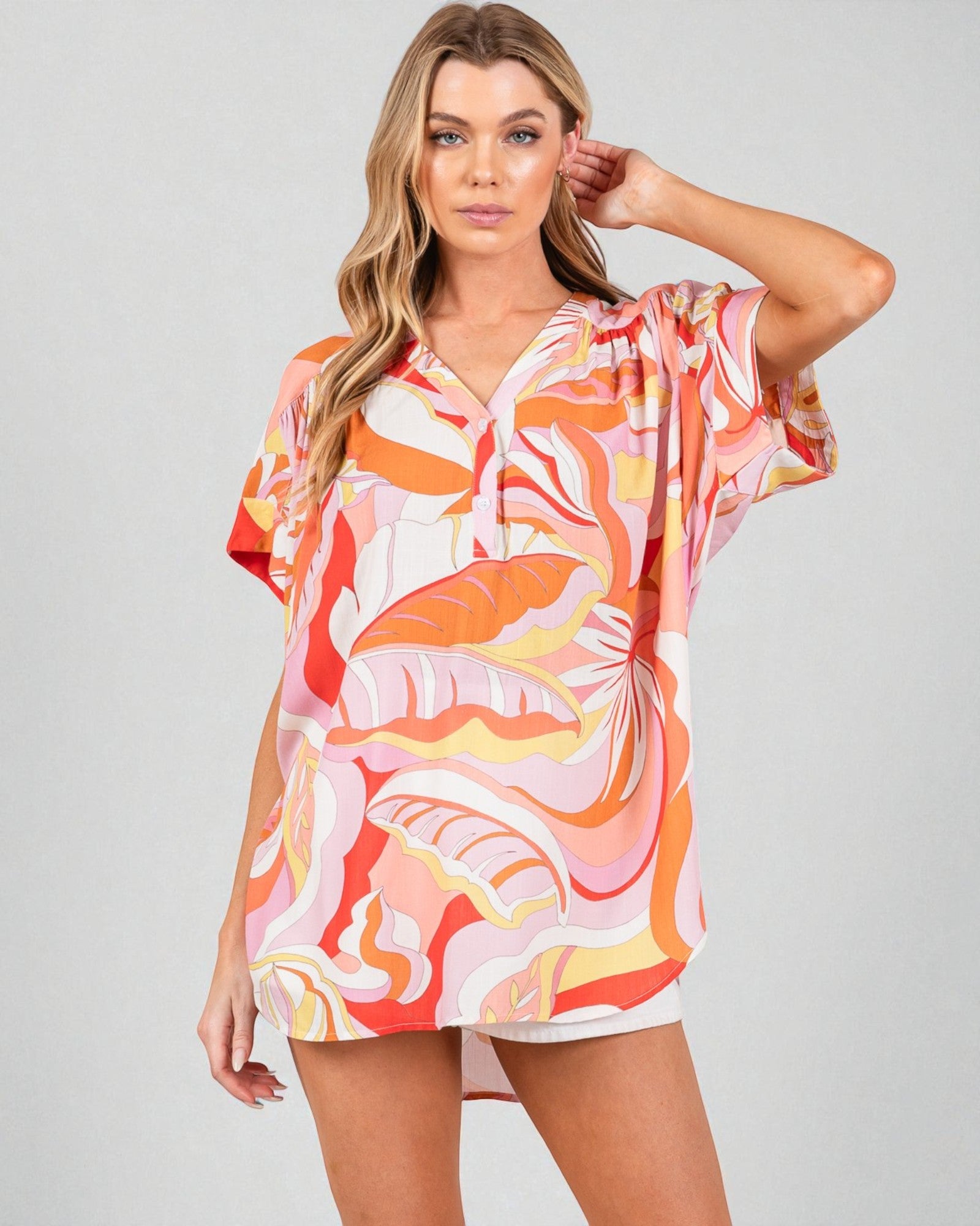 Woman wearing a colorful patterned dress on a plain background