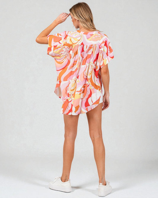 Woman wearing a colorful floral dress on a white background