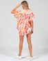 Woman wearing a colorful floral dress on a white background