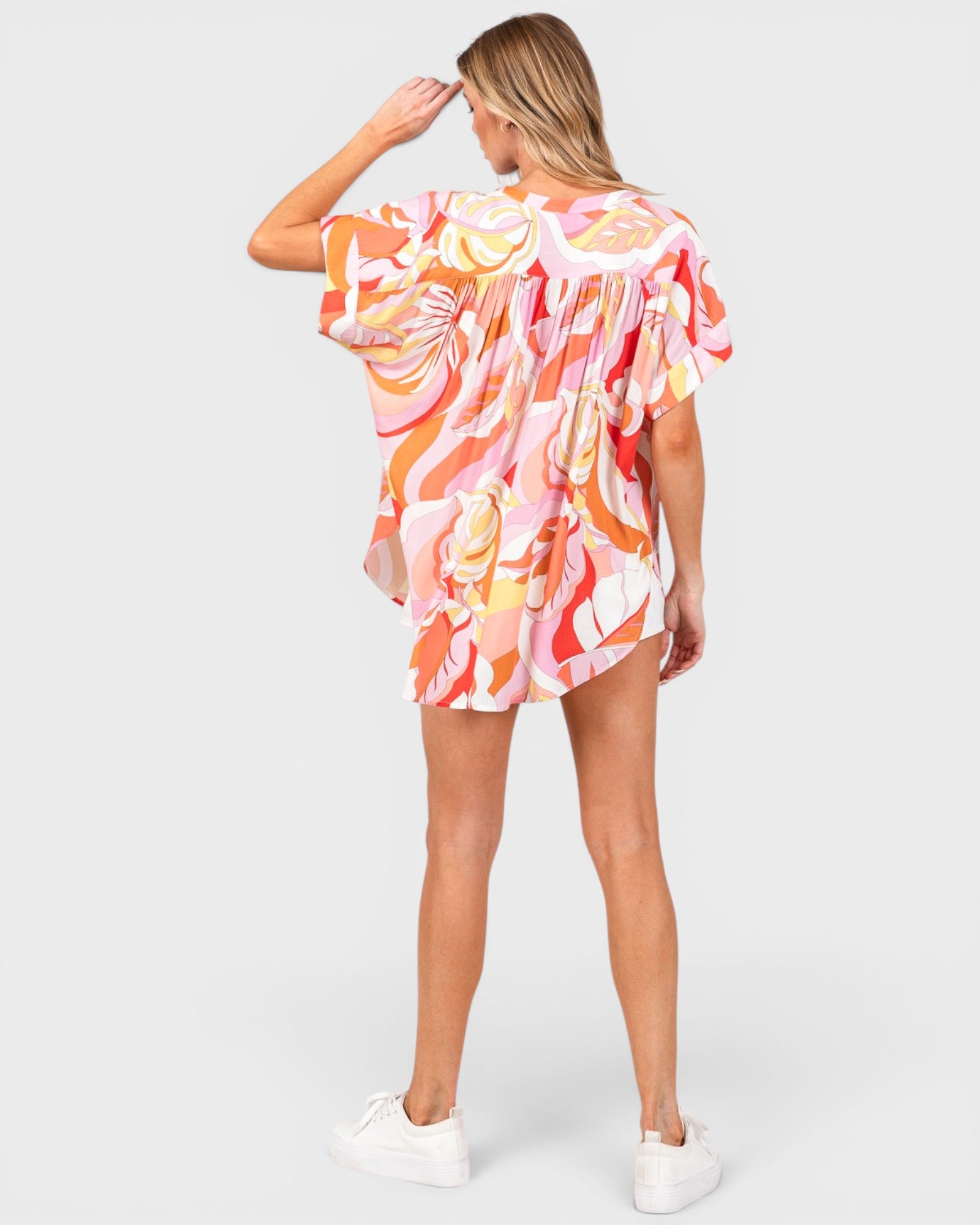 Woman wearing a colorful floral dress on a white background
