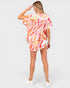 Woman wearing a colorful floral dress on a white background