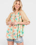 Woman wearing a floral patterned top with a white background