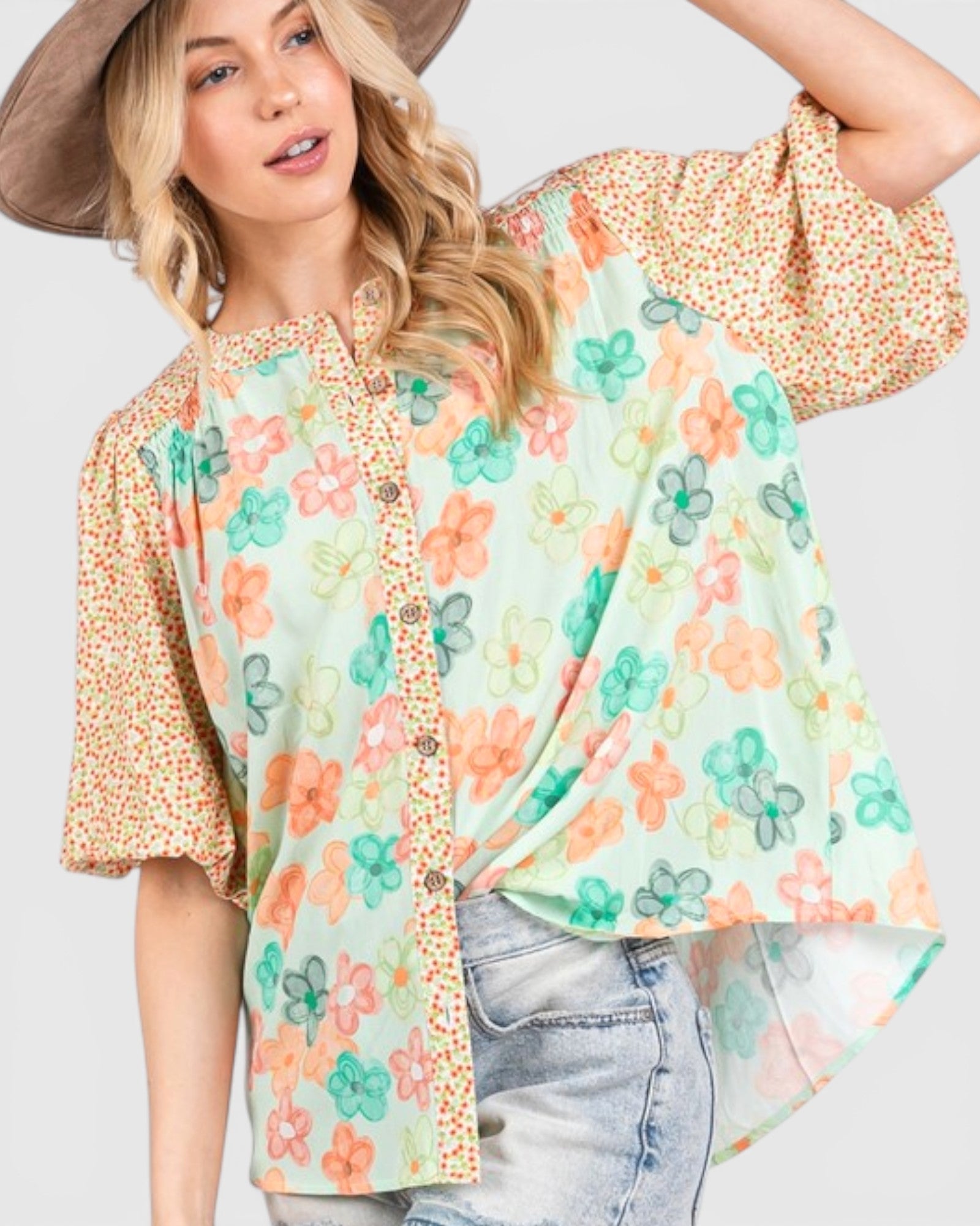 Woman wearing a floral kimono-style top with a plain background