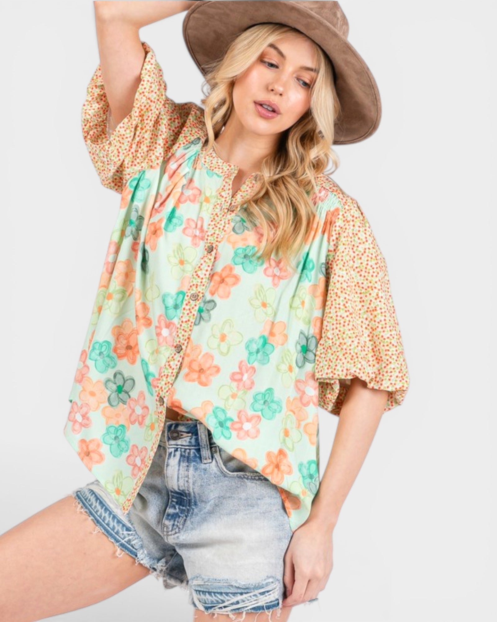Woman wearing a floral kimono-style top with a plain background