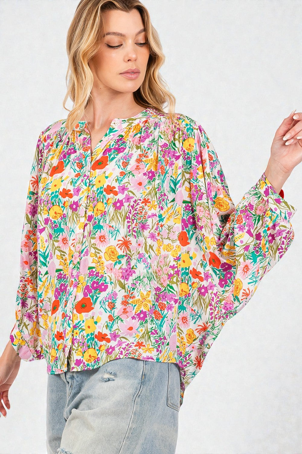 Woman wearing a colorful floral blouse against a white background