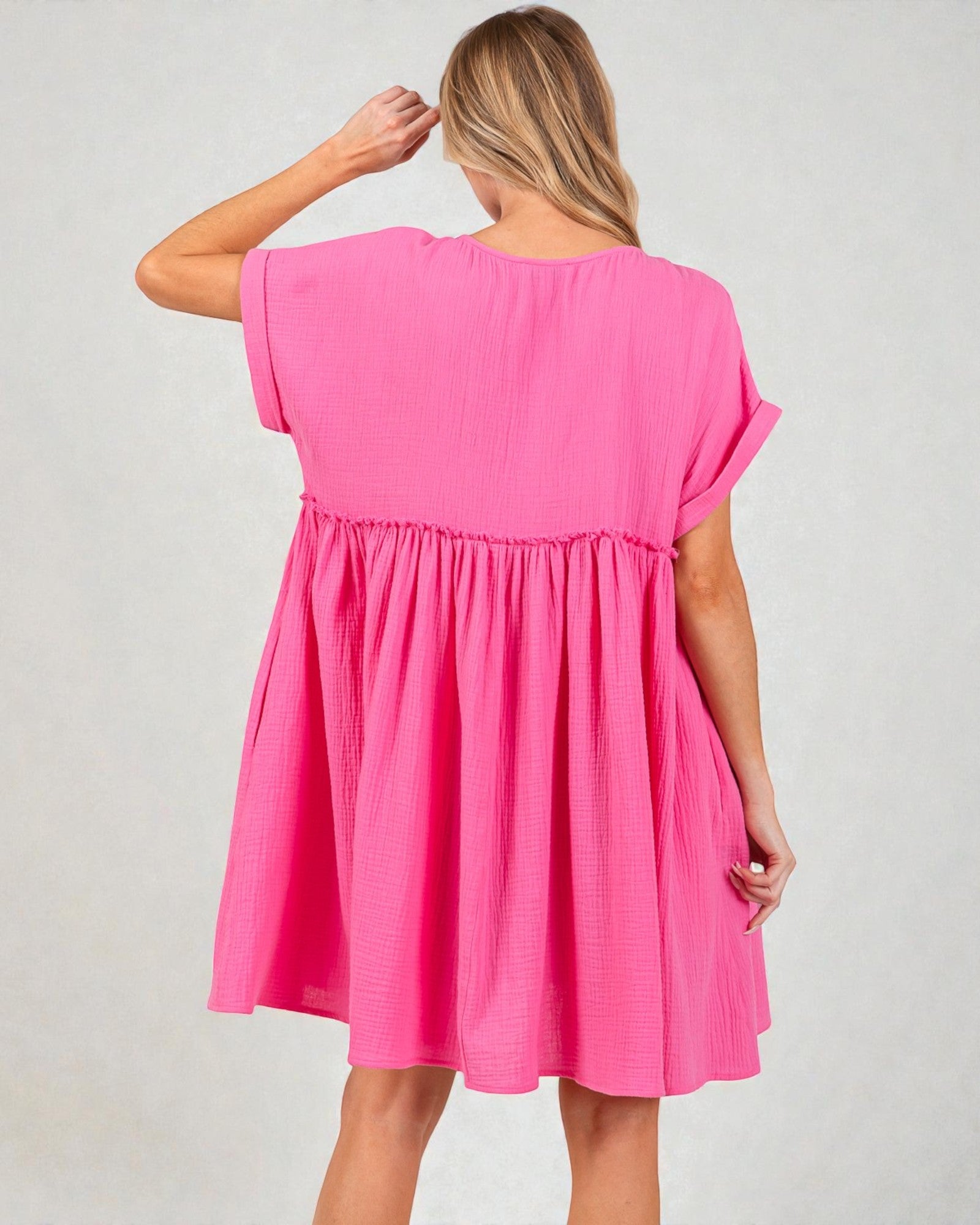 Woman wearing a pink dress against a plain background