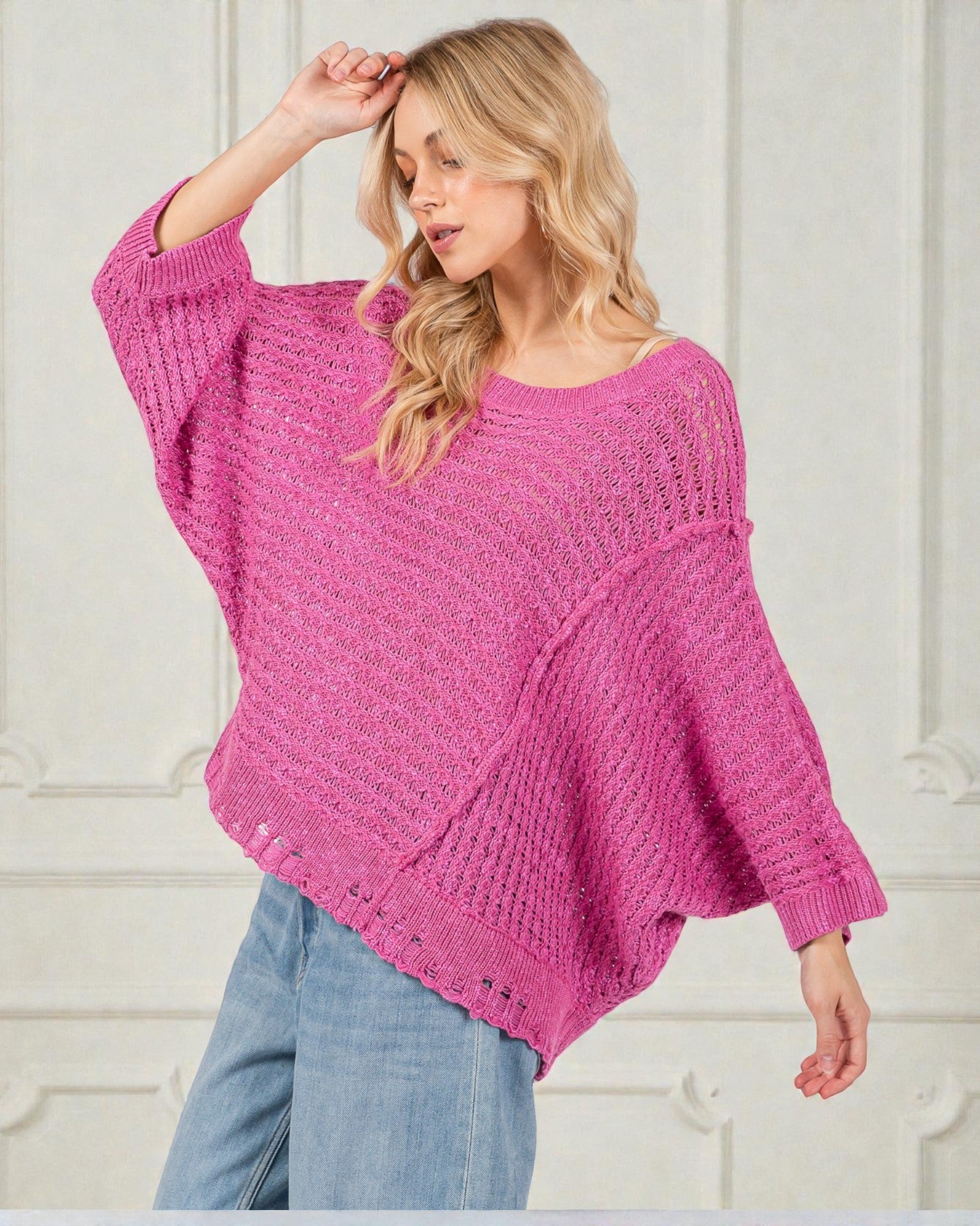 Woman wearing a pink knitted sweater against a white background