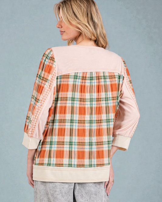 Person wearing a plaid shirt with a neutral background