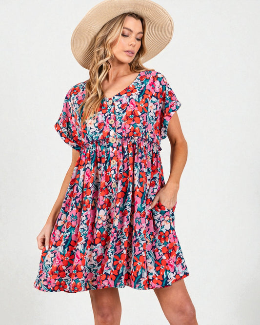 Woman wearing a colorful floral dress and straw hat on a white background