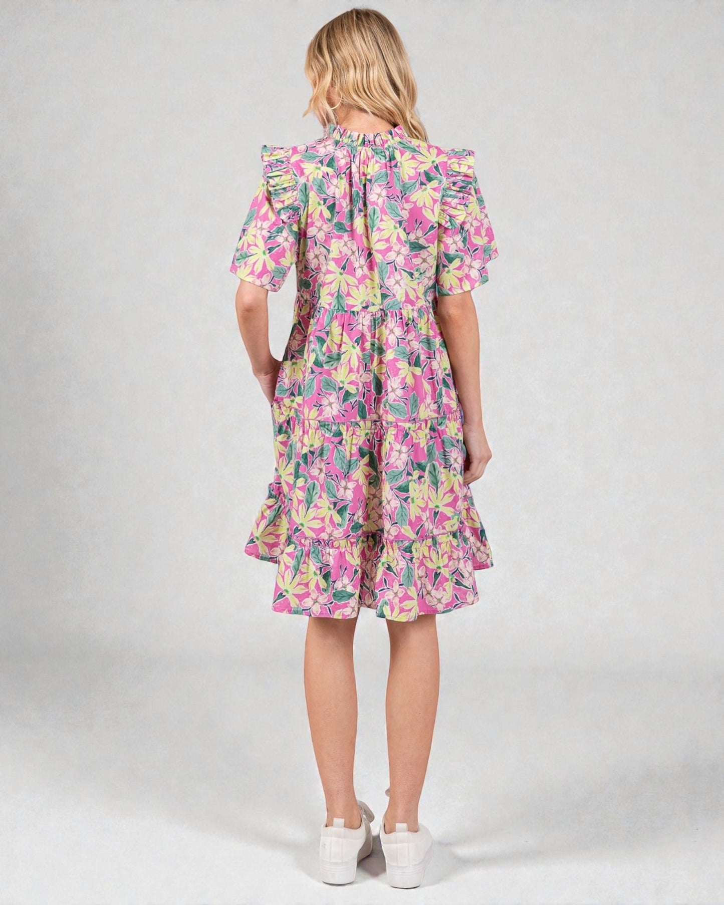 Woman wearing a floral dress on a plain background