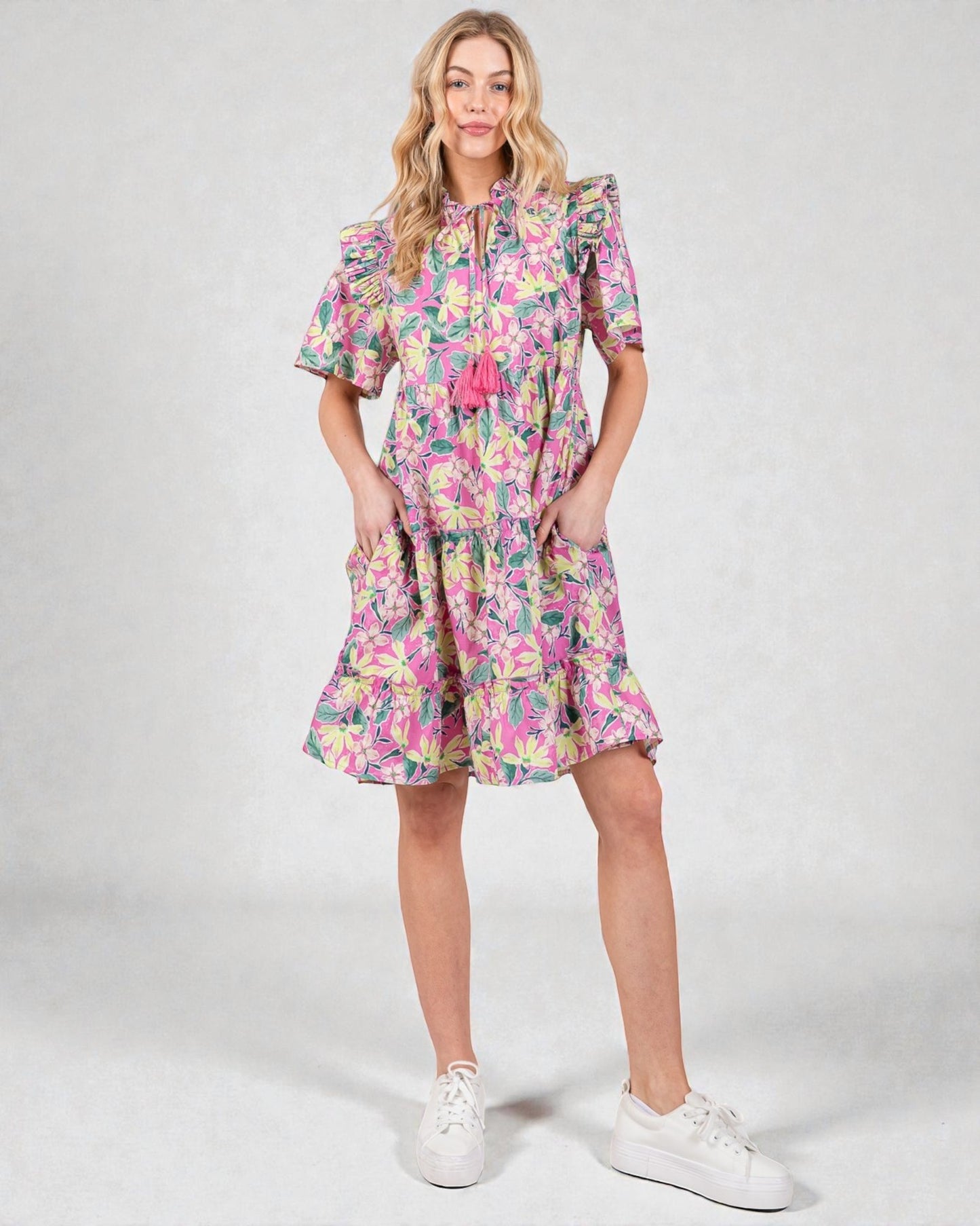 Woman wearing a colorful floral dress on a white background