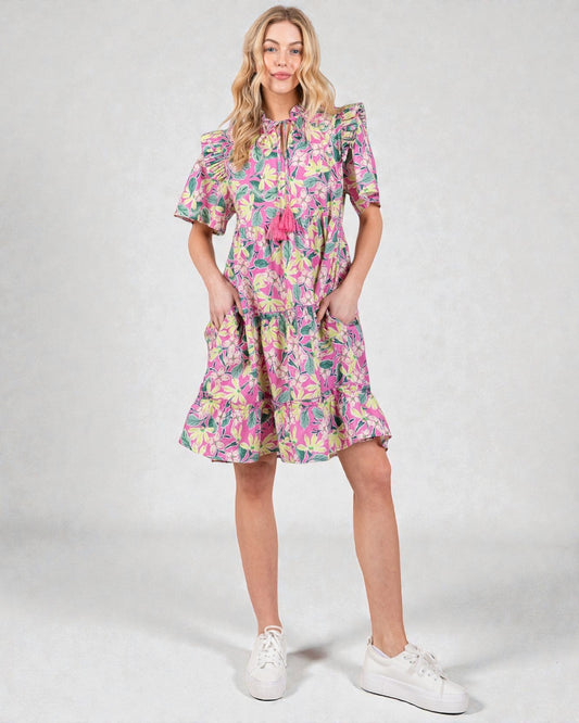 Woman wearing a colorful floral dress on a white background