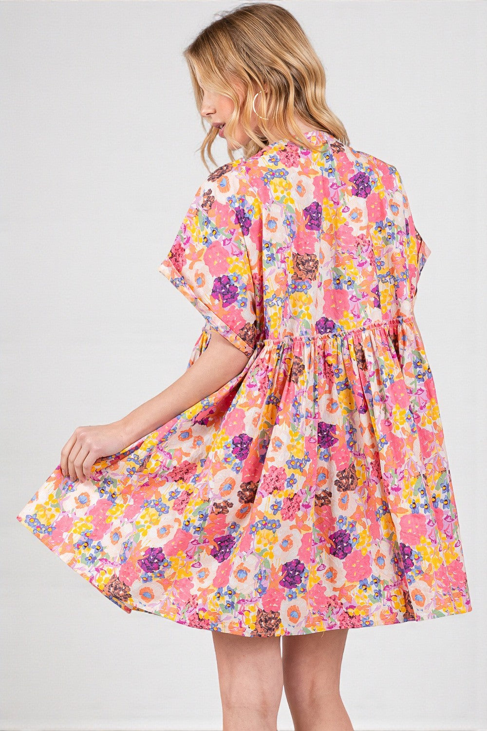 Woman wearing a colorful floral dress on a white background