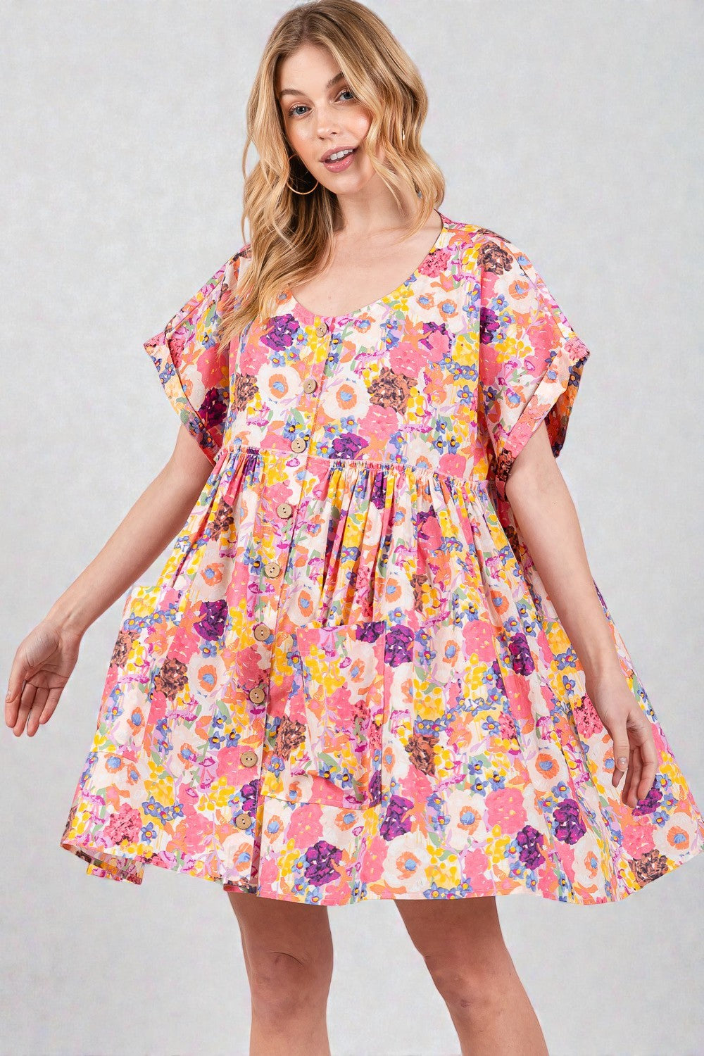 Woman wearing a colorful floral dress on a plain background