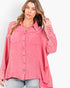 A woman wearing a pink textured button-up shirt with two chest pockets and rolled cuffs, paired with light-wash jeans, against a plain white studio background.