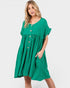 A woman modeling a bright green short-sleeve midi dress with a button-down front and side pockets, set against a plain light gray studio background.
