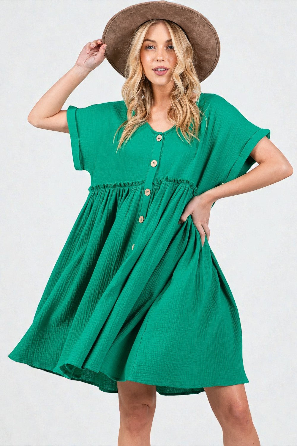 Woman wearing a green dress with a brown hat on a white background