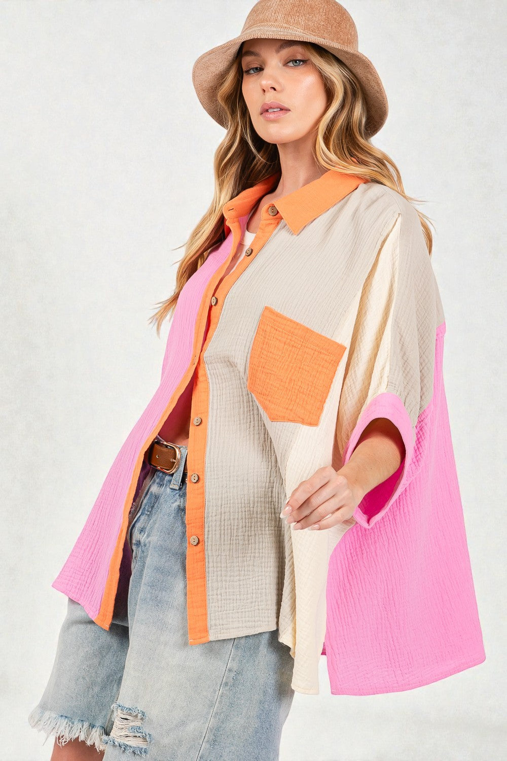 Woman wearing a colorful outfit with a pink and orange jacket on a white background