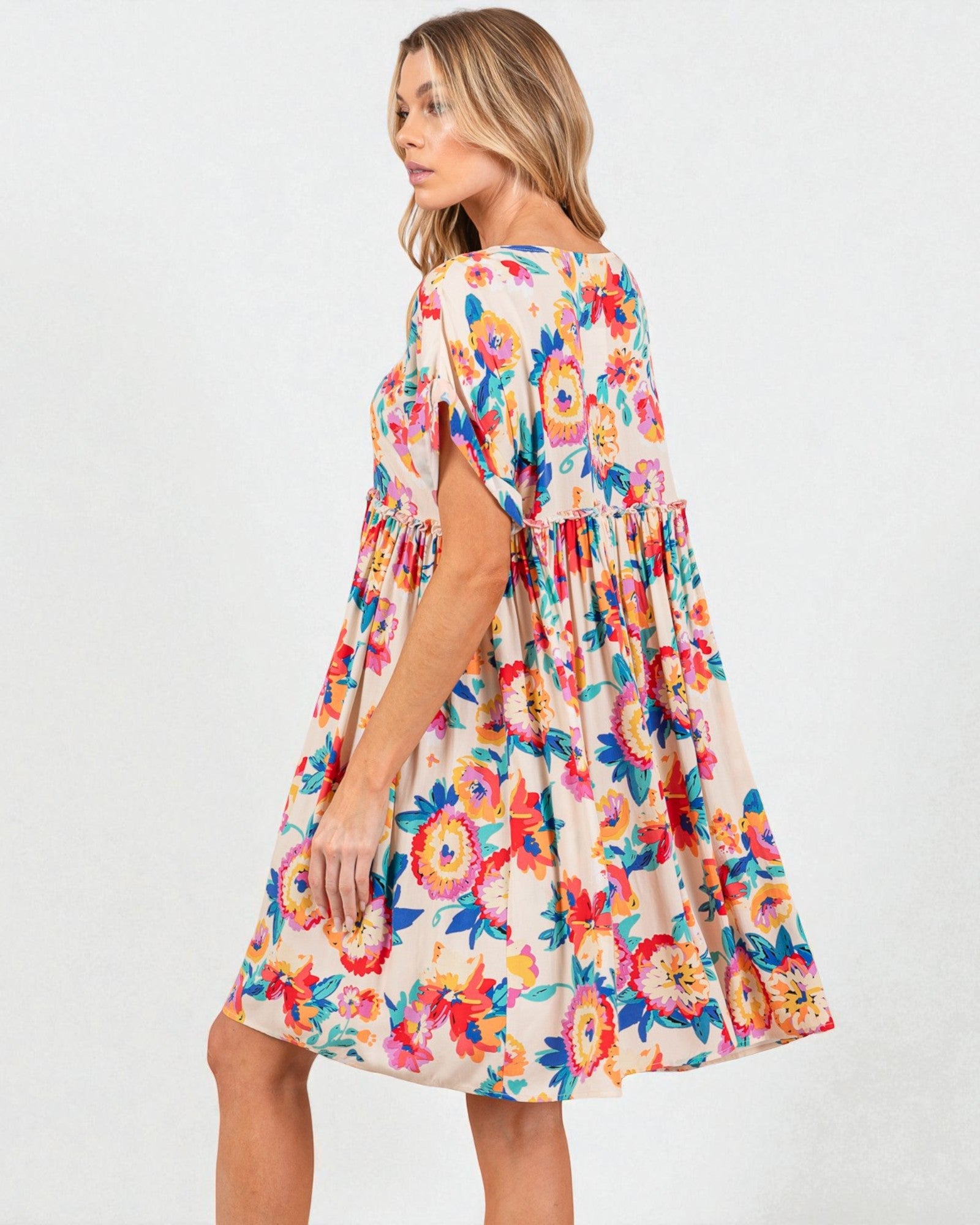 Woman wearing a colorful floral dress on a white background