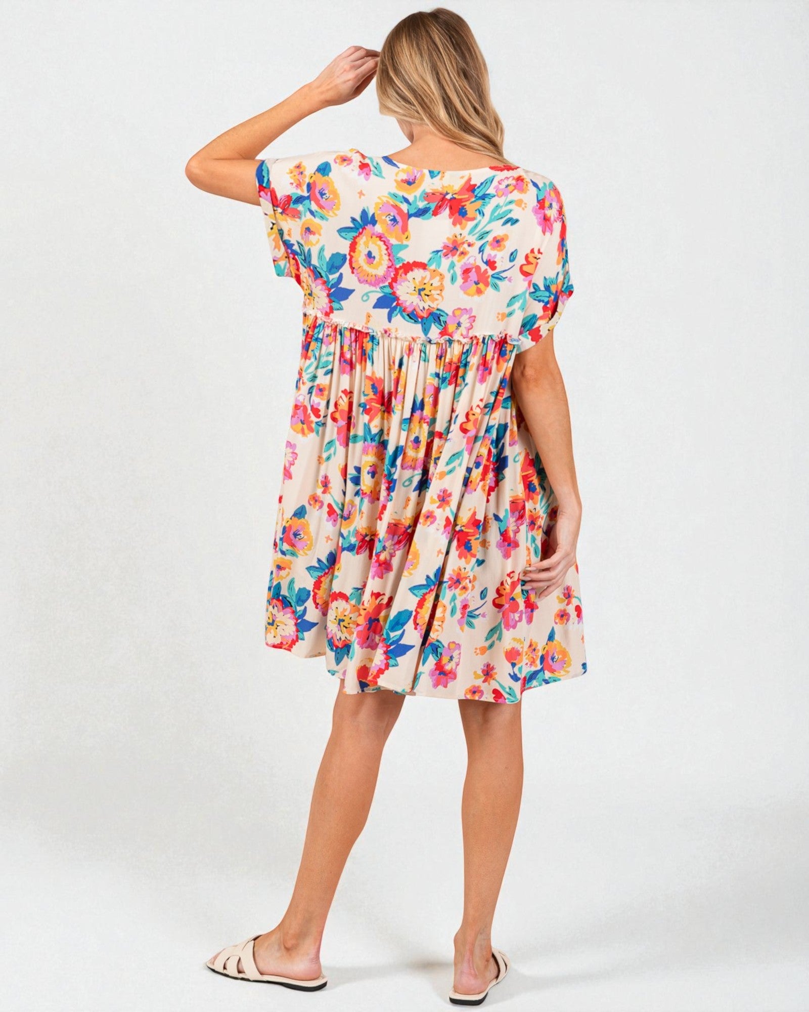 Woman wearing a colorful floral dress on a white background