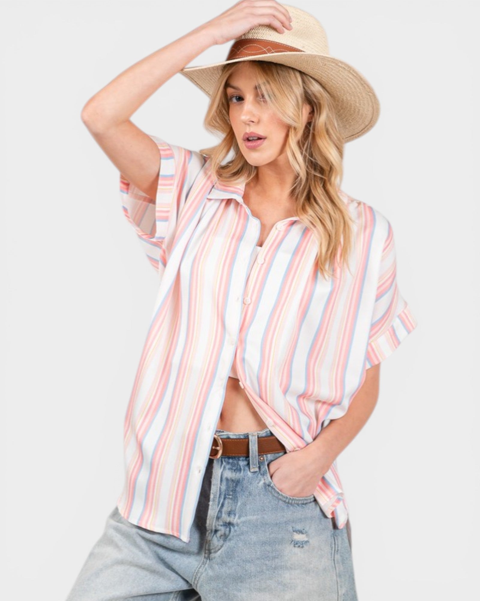 Woman wearing a striped shirt, wide-brimmed hat, and jeans on a white background