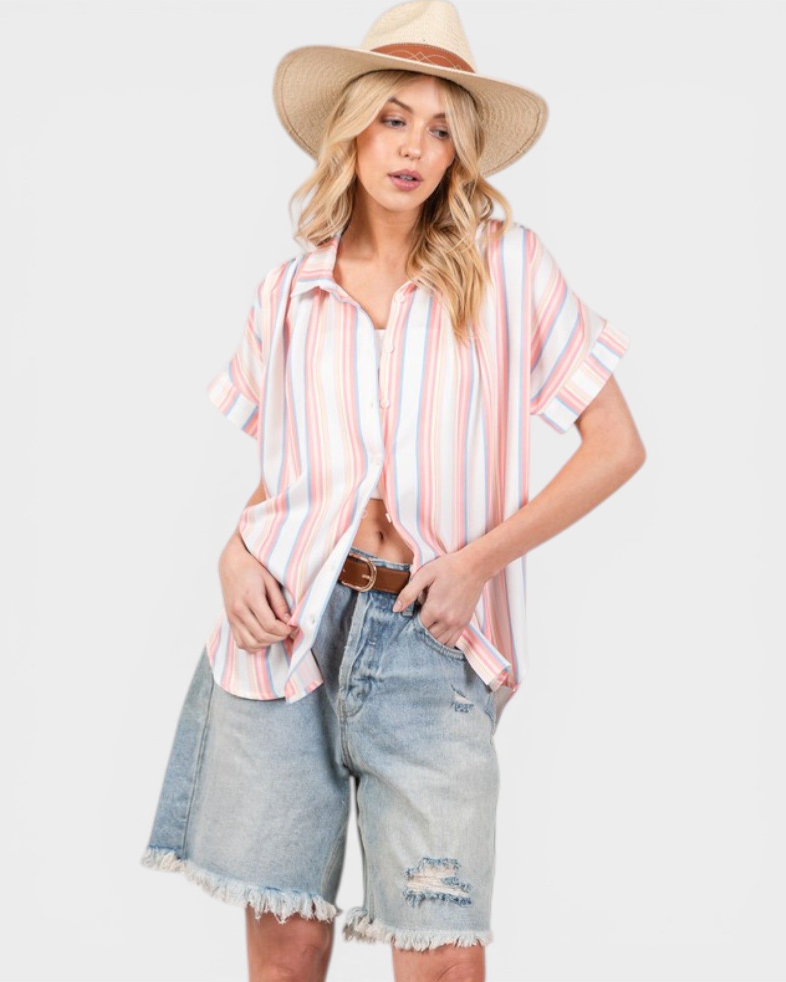 Woman wearing a striped shirt, denim shorts, and a hat on a white background