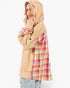 A model wearing a beige hooded sweatshirt with a colorful pink, yellow, and blue plaid patterned lining on the hood, sleeves, and side panels, paired with light-wash jeans against a plain white background.