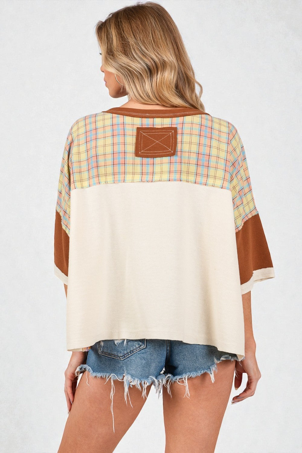 Woman wearing a plaid shirt with a patch on a white background