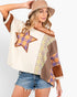 A woman modeling a bohemian-style off-the-shoulder patchwork top with a star patch, plaid details, and brown trim, paired with denim shorts and a beige bucket hat against a light gray background.