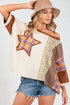 Woman wearing a patchwork top with star design and denim shorts on a white background