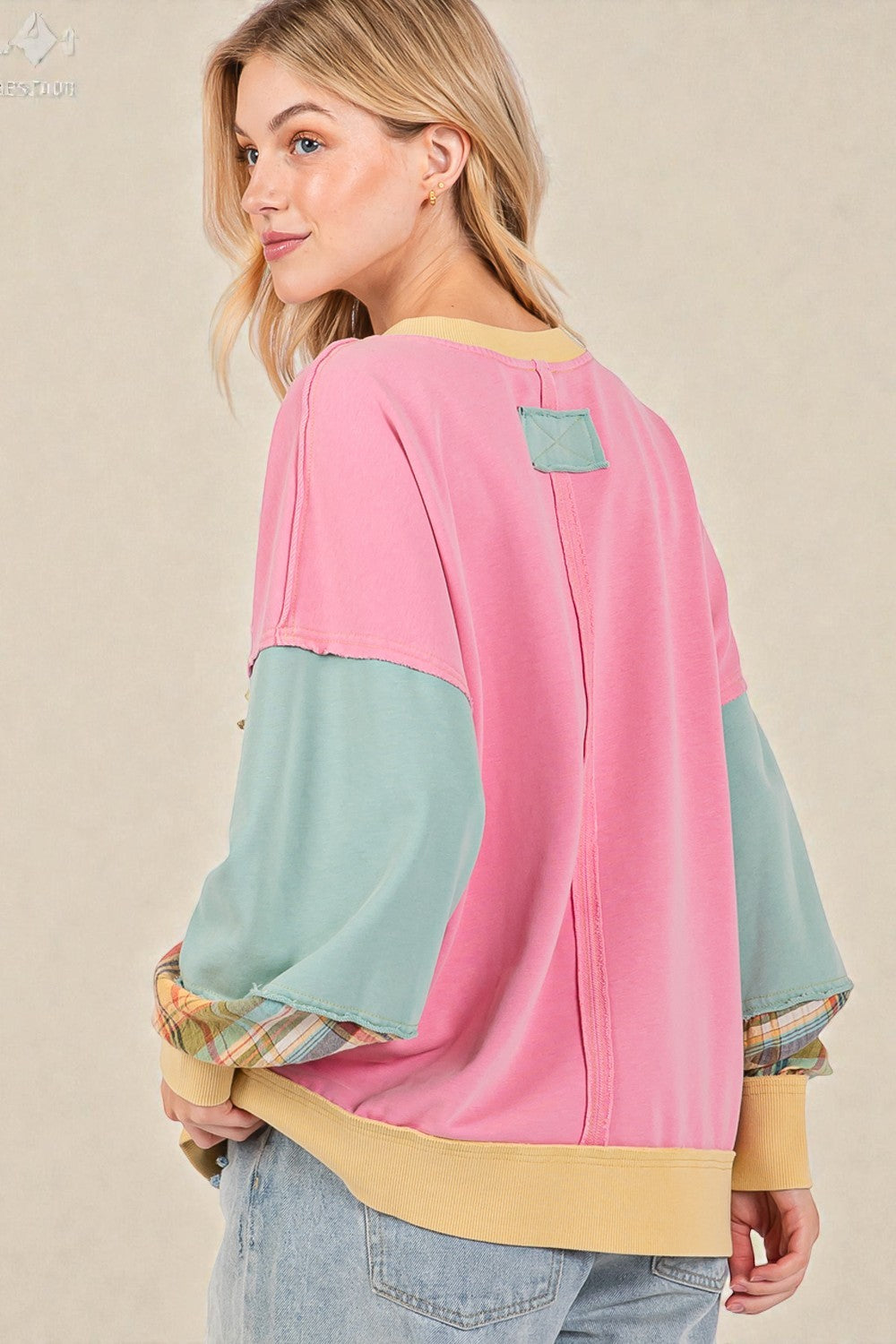 Woman wearing a colorful sweater with a beige background