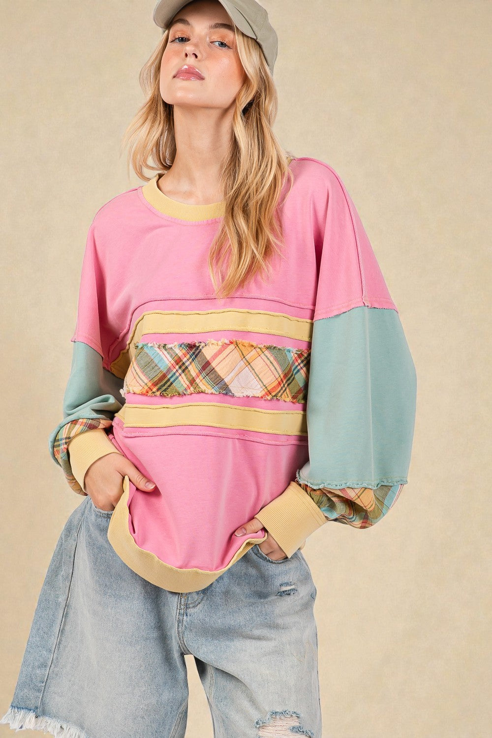 Woman wearing a colorful sweater with plaid pattern on a beige background